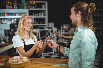 Happy customer giving credit card to waitress