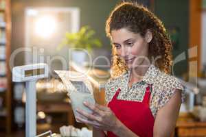 Female staff looking at a grocery item at payment counter