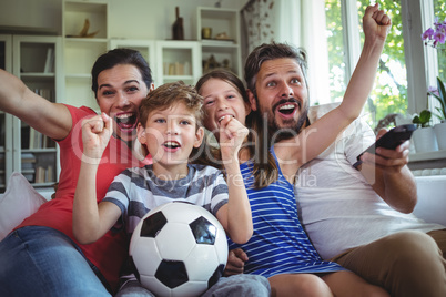 Excited family watching football match