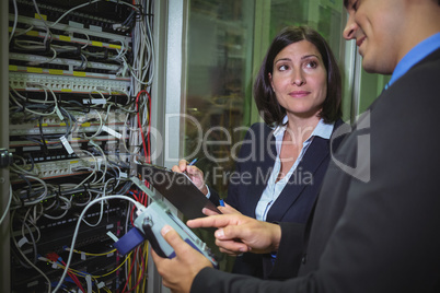 Technicians interacting with each other while analyzing server