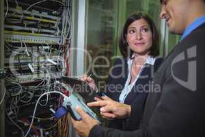 Technicians interacting with each other while analyzing server