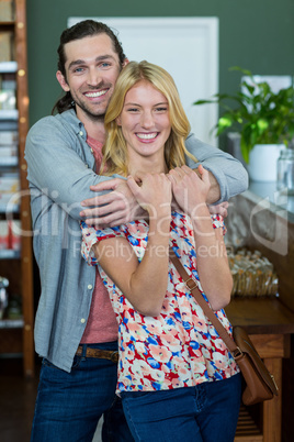 Portrait of happy couple embracing each other in a coffee shop