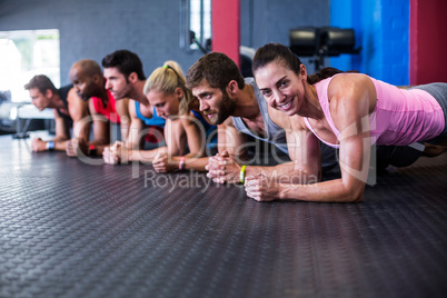 Portrait of smiling woman exercising with friends in gym