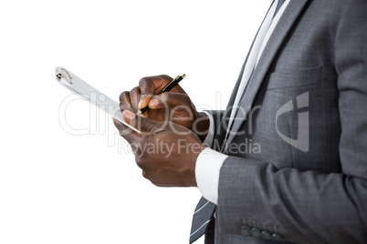 Businessman writing on clipboard
