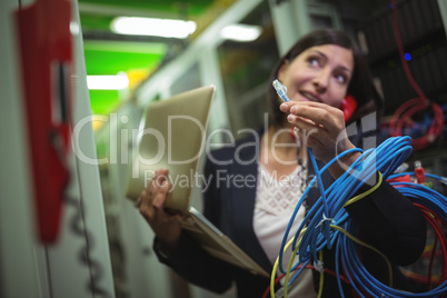 Technician holding internet cable while talking on phone