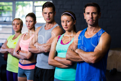 Confident male and female athletes standing in gym
