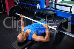 Male athlete doing bench press in fitness studio