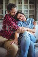Happy couple embracing on sofa in living room