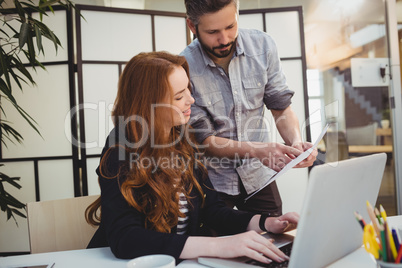 Businessman showing document to female coworker