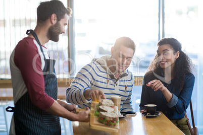 Waiter serving a plate of sandwich to customer