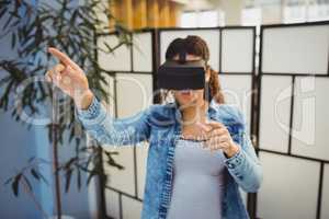Businesswoman pointing while using virtual reality headset