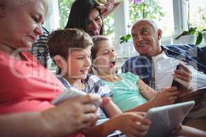 Happy multi-generation family sitting together in living room