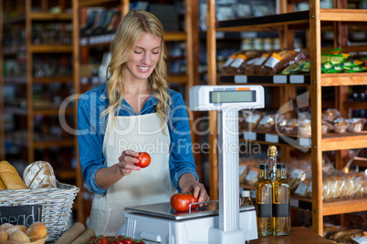 Female staff weighting vegetables on scale