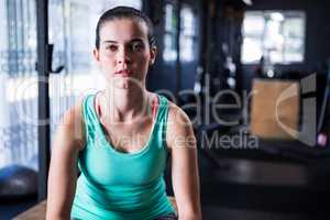 Confident athlete sitting in gym