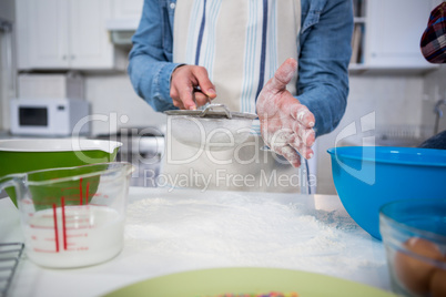 Man sifting flour through a sieve