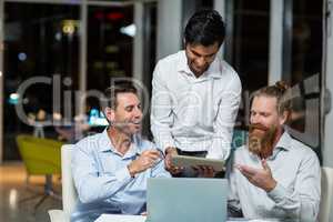 Businessmen discussing over digital tablet