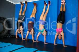 Athletes doing handstand against wall