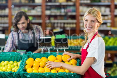 Smiling female staffs checking fruits in organic section