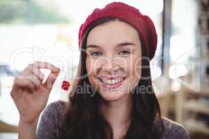 Portrait of smiling woman holding cherry