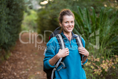 Female hiker standing in forest with backpack