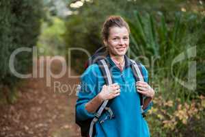 Female hiker standing in forest with backpack