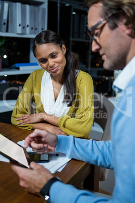 Business executives discussing over digital tablet