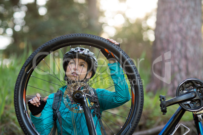 Female biker repairing mountain bike