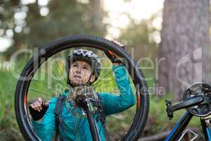 Female biker repairing mountain bike