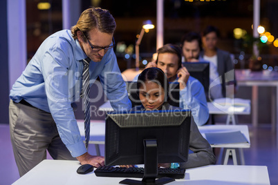 Businessman assisting his colleague in office Businessman assisting his colleague in office