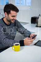 Man using mobile phone in the kitchen