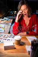 Stressed businesswoman yawning at her desk