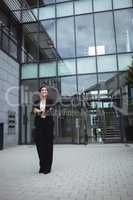 Smiling businesswoman standing in office premises