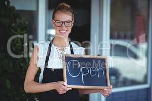 Portrait of waitress standing with chalkboard