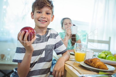 Smiling boy holding an apple