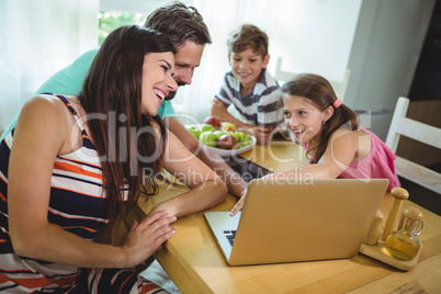 Family using  laptop at dinning table