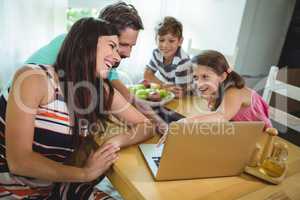 Family using  laptop at dinning table
