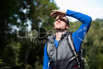 Male hiker shielding his eyes