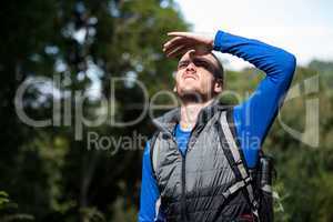 Male hiker shielding his eyes