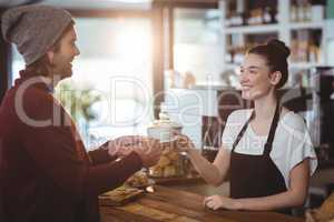 Waitress serving a cup of coffee to customer