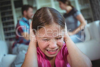 Sad girl listening to her parents arguing