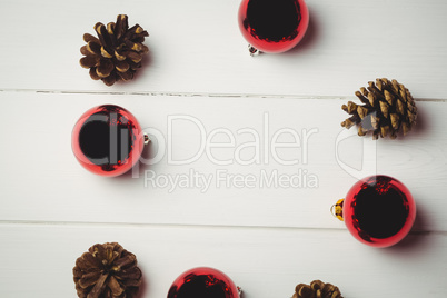 Red christmas bauble and pine cone on wooden table