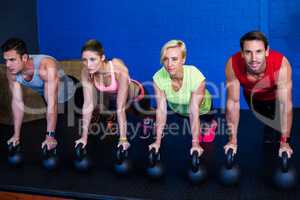 Male and female athletes exercising with kettlebells