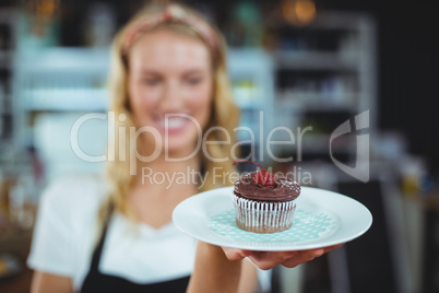 Waitress holding a plate of cupcake