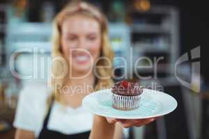 Waitress holding a plate of cupcake