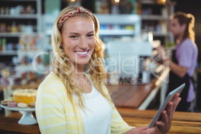 Portrait of smiling woman using digital tablet