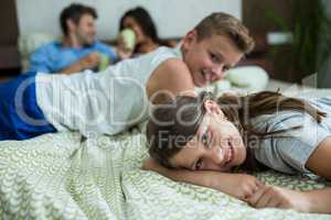 Family lying on bed in bedroom