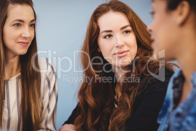 Attractive businesswomen looking at female coworker