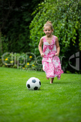 Girl playing with football in park
