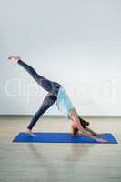 Woman performing yoga on exercise mat