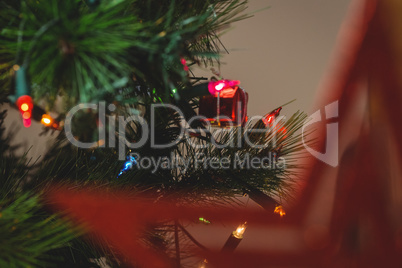 Fairy light and small gift box hanging on christmas tree